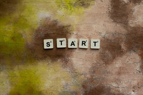 Scrabble letters spelling "START" on a textured earthy background.