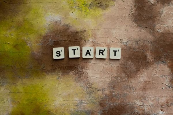 Scrabble letters spelling "START" on a textured earthy background.